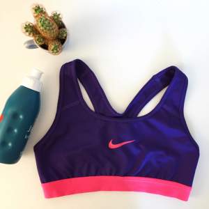 En bekväm lila sport-bh från Nike med rosa detaljer. I fint skick men för liten för mig.  18kr i frakt.