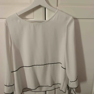  - Vit blus med svarta detaljer och knyten vid armarna, använd fåtal gånger! 