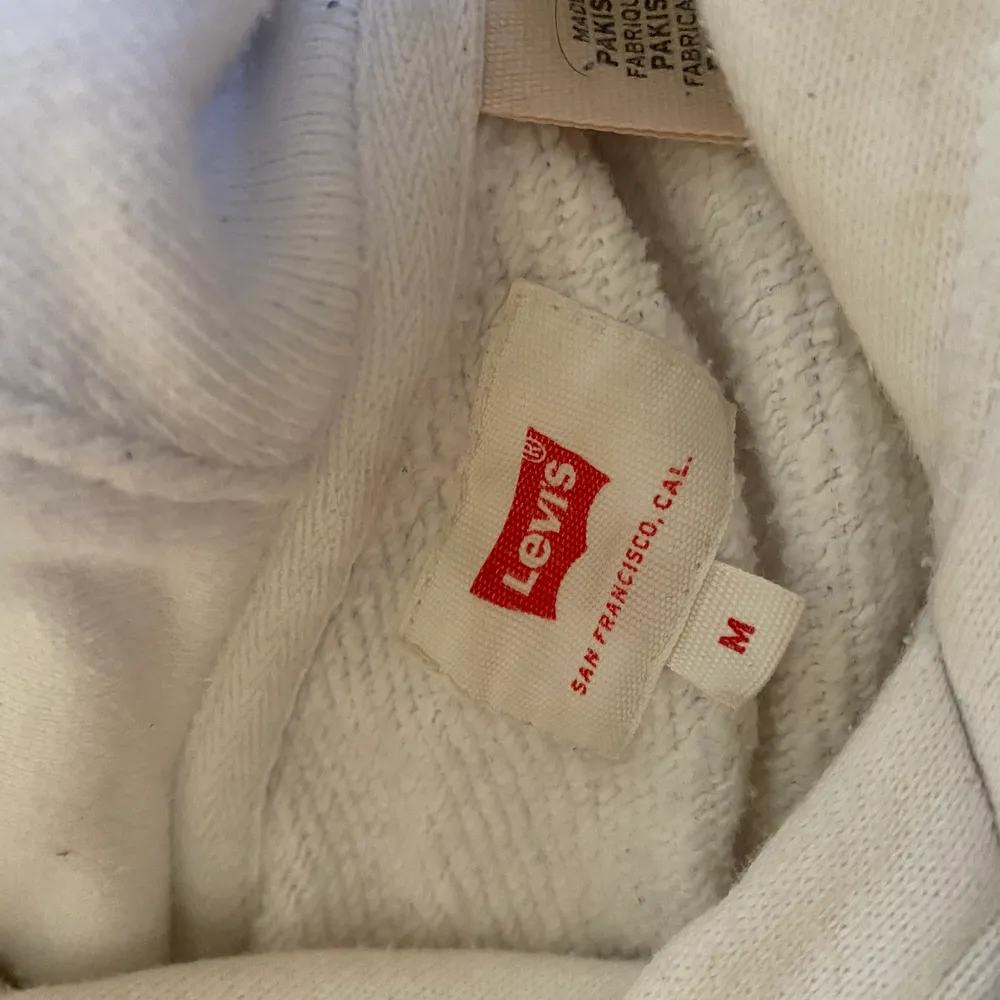 Hel vit Levis hoodie, storlek M för män med en röd logga på mitten av tröjan och en magficka. Köpt ett par månader sen. 1000 kr . Tröjor & Koftor.