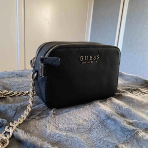  - Axelremsväska i camera bag modell från GUESS. Väska är i skinnimitation samt i nyskick då den knaptt är använd! Säljs inte längre i butik eller online. Nypris ca 900kr🦋 Pruta på!