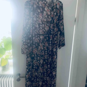 Blommig tunika  - Använd 1 gång  En tunika klänning lång. Kan både knäppas eller ha öppen som en lång blus