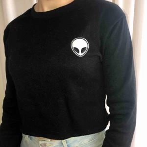 Svart croptop - Svart långärmad tröja med en broderad alien. Det är en kort modell. Materialet på tröjan är lite tjockare, som en hoodie ungefär. Kan mötas upp runt Göteborg. Åker runt en del, så kan även fungera i andra städer. Kan också posta om du står för frakten.