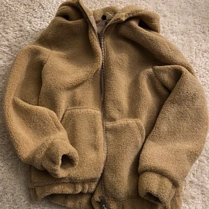Jättefin sherpajacka 🍁 - Säljer denna mysiga jacka med luva i sherpamaterial! Den är i väldigt fint skick och perfekt för vintern 💜 Normal i storleken! Jag samfraktar så kika in mina andra annonser också!