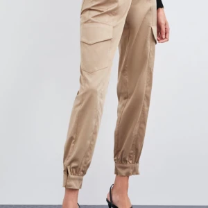 Beiga cargobyxor i satin från zara - Beiga cargobyxor i satin från zara! Endast använd fåtal gånger. Kan skicka mer bilder om det behövs, storlek S, pris 100 kr