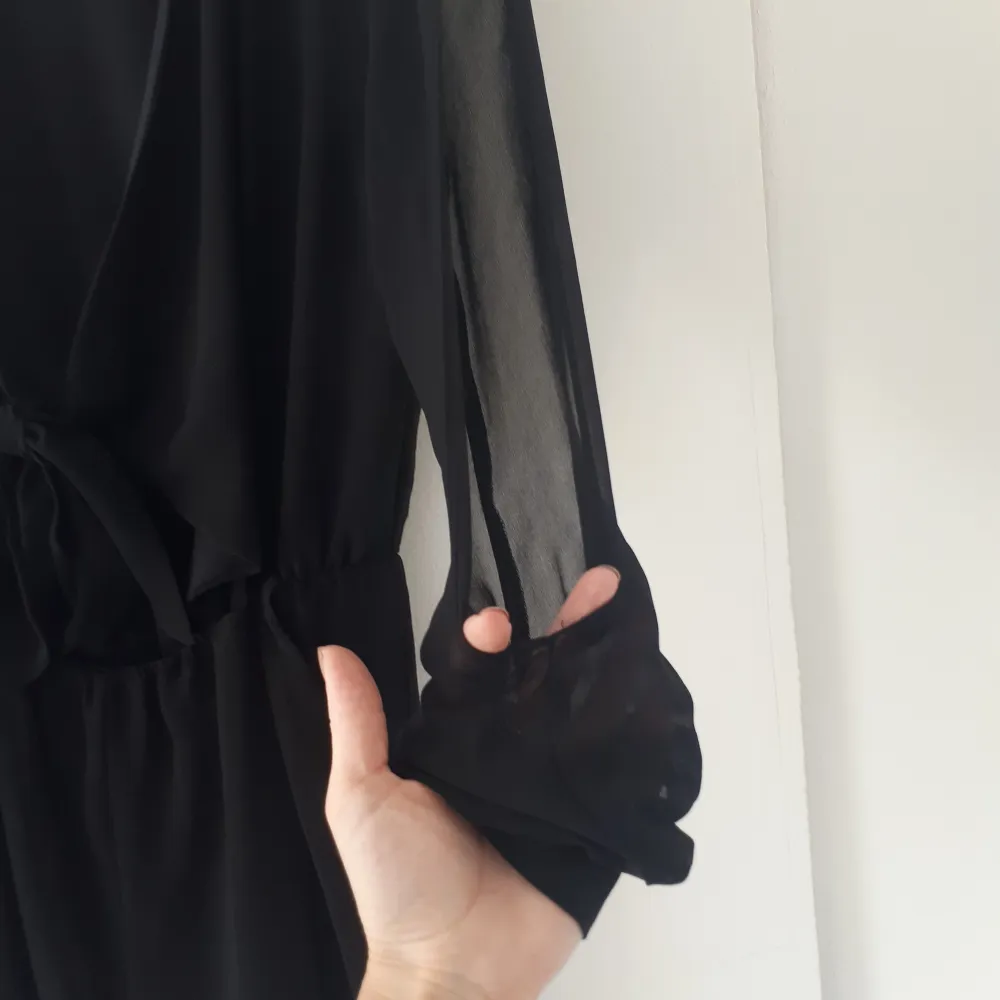 En svart, v-ringad jumpsuit med öppna ärmar. Använd men i bra skick 🖤. Toppar.