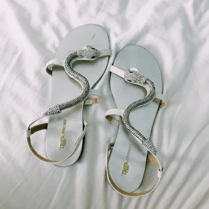 Unika sandaler med orm på i strl 36 - Unika och SÅ FINA skor med en silvrig orm på i strl 36 som min mamma köpt i Italien i början av 2000-talet. Bra skick!!! Tyvärr inte lagom till mig. 180 kr + frakt (44 kr). Samfraktar gärna om ni köper mer! 