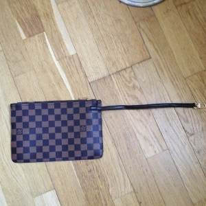 LV väska  - Lv clutch väska (inte äkta) säljs då 2 sömmar gått upp, se bild 3. Man kan antingen sy eller limma tillbaka de på plats. 