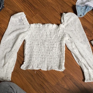 Hm divided, aldrig använd  - Tajt midja med flexibelt tyg pösiga armar, rätt så tun. I slutet av armarna är det tajtare som håller fast armarna 