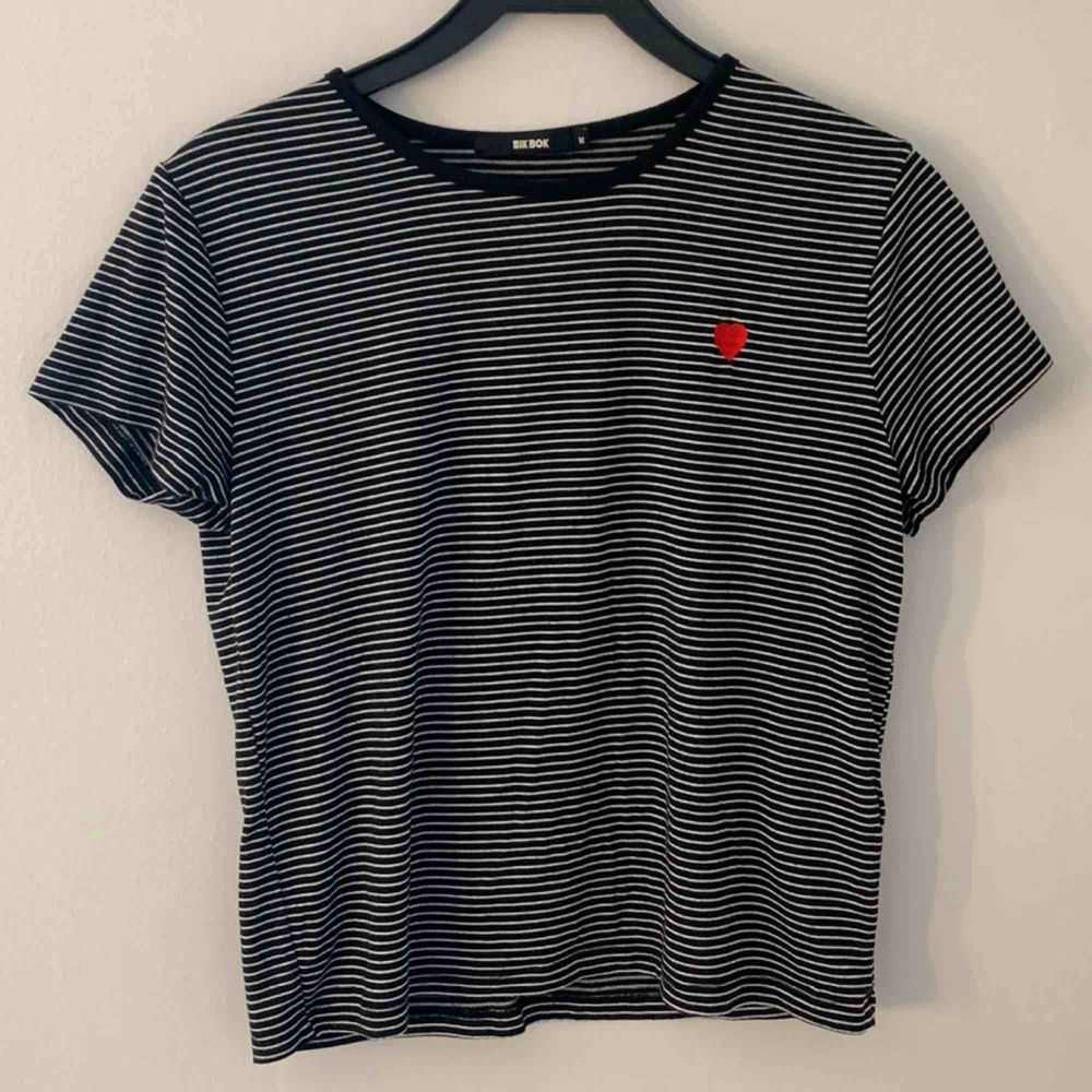 Randig T-shirt med ett rött hj | Plick Second Hand
