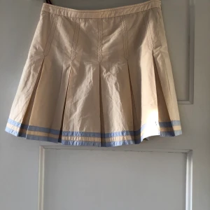 Fin kjol - En fin kjol i beige och ljusblått med två ljusblå sträck längst ned, Hugo boss frakten ingår ej i priset.