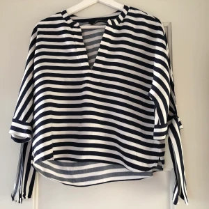 Söt blus - En fin sommarblus, blå och vit randig, från zara, knyten i ärmarna, v-ringad. Frakt ingår ej i pris.