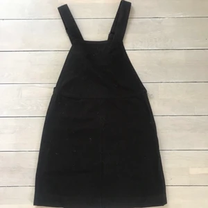 Weekday jeansklänning - Svart jeansklänning med hängslen och dragkedja på ena sidan 