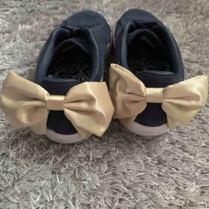  - Blåa pumaskor med guld rosett på hälen, 24,5 cm innermått.  Använda en gång. Köpare betalar frakt