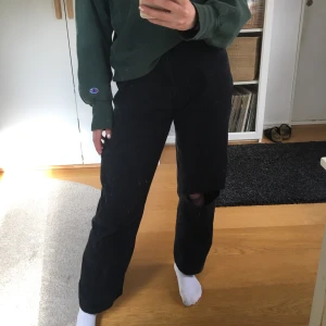 Svarta jeans med hål - Säljer dessa svarta jeansen med hål både på knät och där bak. De sitter bra i längden på mig som är 167cm men stora i midjan men funkar perfekt med skärp (brukar ha W25/stl.34). Märke: Mc Gordon
