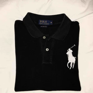  - Svart, figursydd piké från Ralph Lauren i storlek M men passar mig som är en S. Mycket sparsamt använd och är i nyskick! Köparen står för frakten💕 OBS det är endast på bilden det blir förändring i färgen!!! 