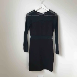  - Svart festklänning med ”genomskinliga” ärmar. Använd ett fåtal gånger. Köparen står för fraktkostnad enligt postens portotabell.