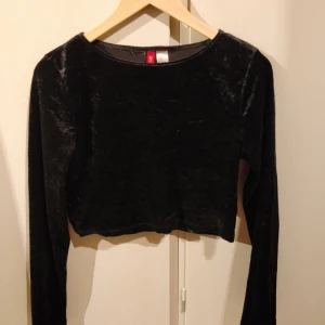  - Supersnygg croptop med långa ärmar, av svart sammet. Bra kvalité och härlig passform. Säljs pga för liten tyvärr. Perfekt till utgång, fest eller till vardags. Passar allt!