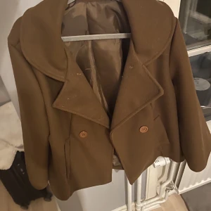 Kappa - Säljer min bruna kappa då den är fin men aningen kort i ärmarna för mig med långa armar! Kort modell. Köpt i Italien därav osäker på märket. Den passar för mig som är vanligtvis storlek S och 164cm! 