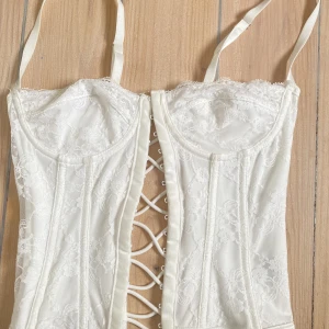 Vit korsett topp - Jätte snygg vit korsett topp, säljer då jag tycker den är lite för liten för mig. Den är lite ”tuffsig” på höger kupa uppe, syns om man zoomar in på bilden, kom annars privat för bätte bild❤️❤️