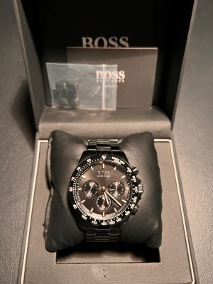 Hugo Boss klocka - Säljer nu min Hugo Boss klocka som jag fick i julklapp. Använd 2-3 gånger. Klockan är i rostfritt material (Stainless steel) och även vattentätt. Justerbara länkar ingår och även original boxen. Ny pris 4.500 Mitt start pris 1.500kr