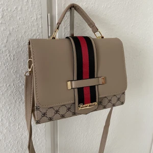 Väska  - Super fin!! Ganska liten väska, som kommer med en plånbok liknande sak med en kedja ( 100kr extra med den) 