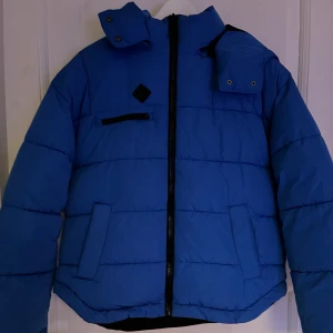 Vinterjacka  - Blå vinterjacka som är väldigt varm och skönt till vinter. Köpt förra året och bara använd några gånger. Ser helt ny ut