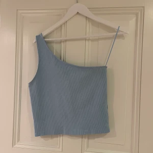 Topp GinaTricot  - One shoulder topp från GinaTricot i fin ljusblå färg! Storlek L, 70kr+frakt 