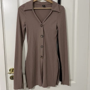 Brun ”cardigan” - Ärmarnas ände har en ”öppning” som ni ser på sista bilden. Jag känner att den satt lite för tight på mig. Köpt på nätet så det blir svårt att lämna tillbaka så jag säljer den. 