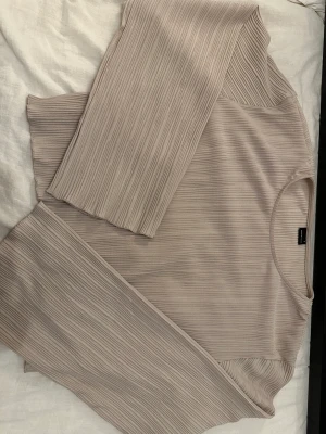 Beige topp - En beige topp från GinaTricot. Kort i modellen med långa armar