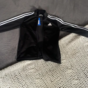 svart adidas zip up - jättefin adidas zip up som jag köpte från sellpy! fick hem den igår men tyvärr så var den för liten för mig. lappen är kvar! den har en liten fläck på armen (se bild 2) men den syns inte alls på!