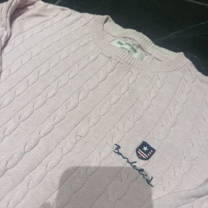 Kabelstickad tröja  - En kabelstickadtröja från bondelid i färgen rosa. Storlek S. 