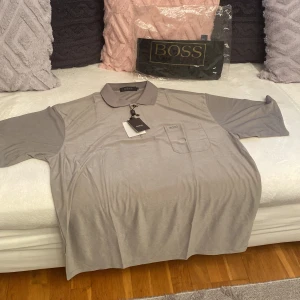 Hugo Boss piké tröja . Ny ! - Hugo Boss typ pikétröja. Helt ny med förpackning och taggar. Stl xxl. Färg grå.
