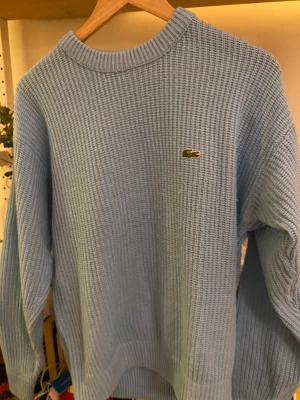 Lacoste stickad crewneck - Turkos Lacoste tröja. Lite mindre i storleken.
