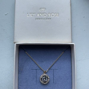 Halsband från Lily and Rose  - Säljer mitt helt nya Lily & Rose halsband i guld med smokey maveu färgad sten.