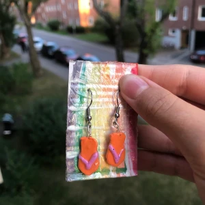 Sandal/flipflops örhängen 🩴 - Sandal Örhängen i orange och lila, ca. 2x1 cm, gjorda i skumlera med lager a lack. Krokarna är i kirurgisk stål så även alergiska kan bära dem ~ 🩴
