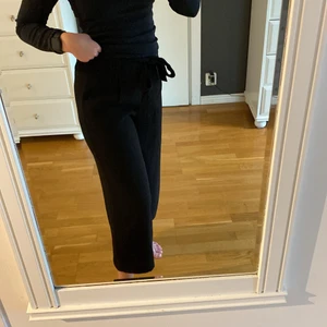 Svarta byxor - Svarta utsvängda byxor från Zara i storlek XS, passar även som S då det finns resår i midjan. Även knytning framtill. Går en bit ovanför anklarna på mig som är 165 cm lång.