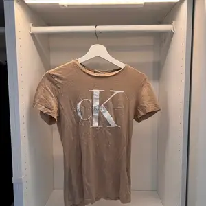 Beige T-shirt i storlek M