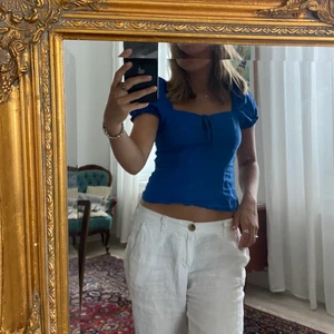 Blå linnetopp från HM i strl 34 - En blå topp med puffärmar i linne från HM i strl 34. Storleken är lite större och skulle därför säga att det passar strl XS-S. 