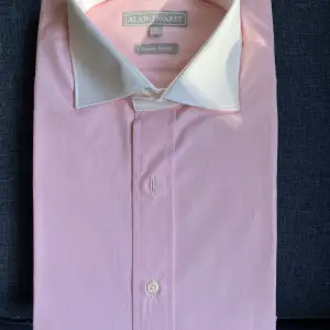 Previously called Alain Figaret, is a French luxury shirt brand. Shirt size 39/15.5 New and never used Stylish with white collar and pink-ish body Check www.figaret.com to compare original price.