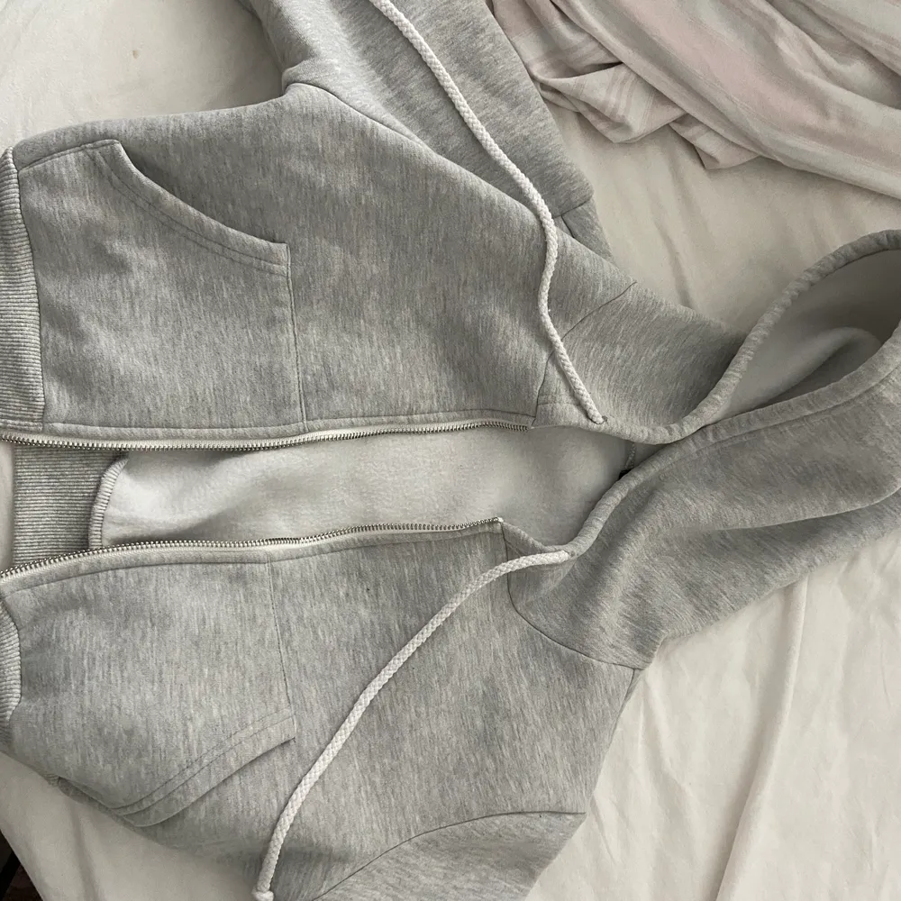 En croppad zip up hoodie i nyskick ! Sjukt fin men används inte skriv för mer frågor :) säljer massa mer tröjor , toppar, hoodies etc så in o kika 💕. Hoodies.