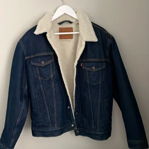 Levi’s jeans jacka med foder  - Detta är en jeans jacka fåren Levis som sagt. Den har inte blivit använd pågrund av väder den är som ny. Efter som att den ute har blir andvänd så är den inte ingåd altså att den fortfarande lite hård men det går fort att gå in och jag har haft en innan och älskat den den har tyvärr blivit för liten och det är därför jag säljer den 