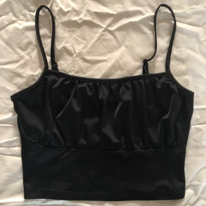 Svart topp från HM - Fin svart topp med ”rush” där framme som ser väldigt fint ut. Banden är justerbara. Toppen är knappt använder och  är i storleken M.💕