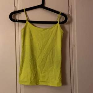Ett  neon gult linne som är köpt i stockholm men vet inte vilken butik. Den är inte använd mycket och är i fint skick. Den är i storlek S 