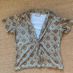 70- tals skjorta/blus - Ascool sjuttiotals skjorta med korta ärmar i velvet liknande material och snygga färger. Köpt på humana! 