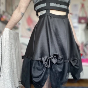 Hemmasydd kjol med tyll - Svart kjol som tidigare ägare sytt fast rosetter och tyll på. Inte använd av mig. Uppskattas till S/M (midja 70cm) saknar märkning. Lite trådig här och var, därför säljes den billigt. Någon kanske vill pyssla ihop något med den 😅 frakt tillkommer. 