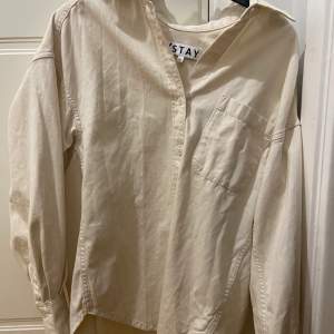 Beige/vit skjorta från Stay. Knappt används, den är som ny! Storlek XS men den är over-size så skulle snarare säga att det är en S/M.