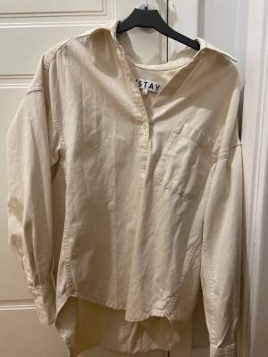 Beige/vit skjorta från Stay. Knappt används, den är som ny! Storlek XS men den är over-size så skulle snarare säga att det är en S/M.