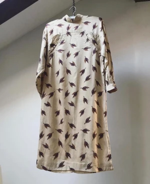 Vintage klänning  - Unik KLÄNNING Ljuva tidiga 80-tal. Här är en klänning som verkligen passar till alla tillfällen. Beige färgad med små detaljer i brunt 8 löv ) bra skick  Storlek XS/S Pris 650 kr ( ink frakt )   Byst 98 cm ( rak modell )  Längd 104 cm Ärm 43 cm 