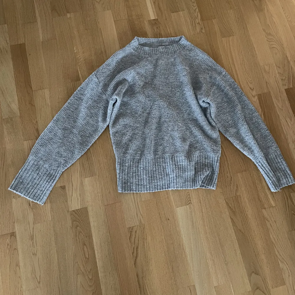 En grå stickad tröja från Lindex barn i storlek 164. Tröjan är lite nipprig men annars i bra skick. Stickat.