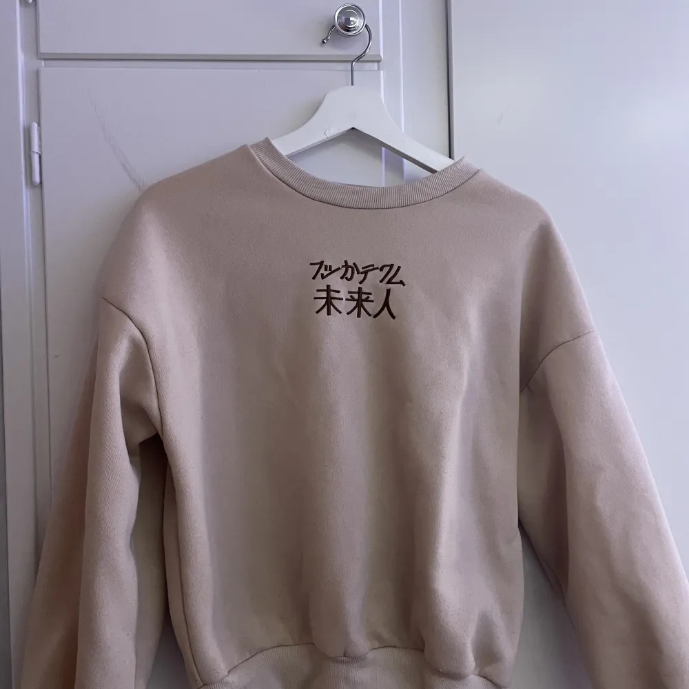 Beige sweatshirt med japanska tecken på! Knappt använd och supervarm . Tröjor & Koftor.